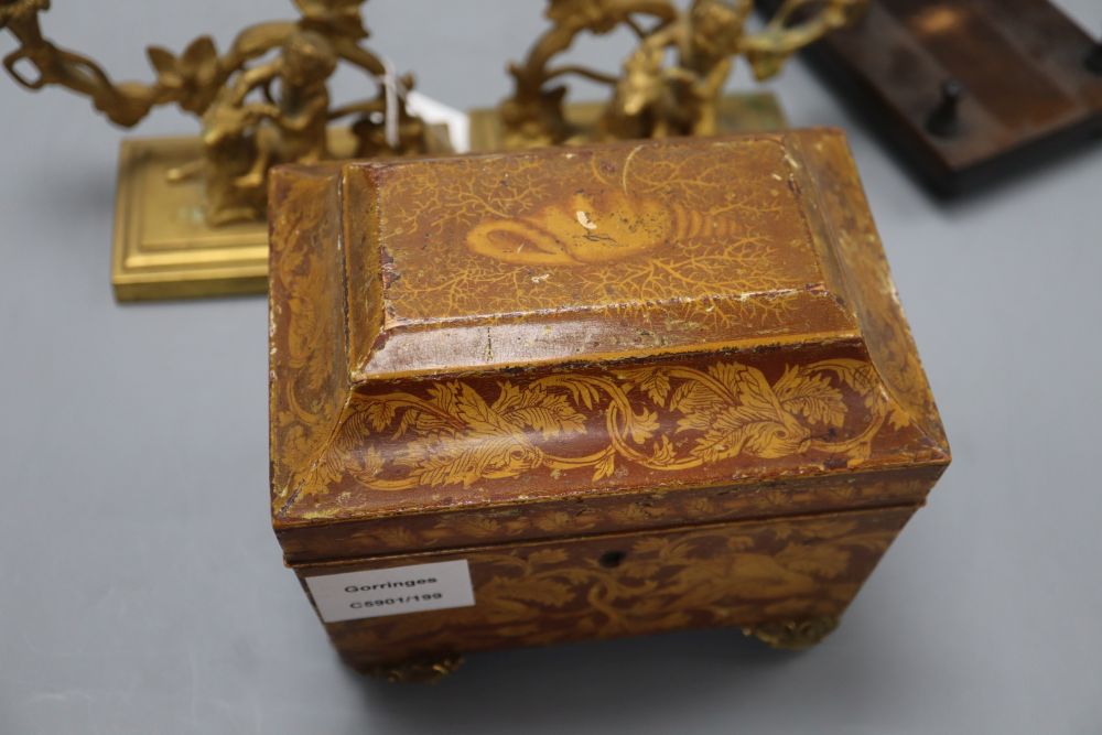 A William IV penwork tea caddy, a pair of ormolu Bacchanalian cherub candlesticks, lacking sconces and a hardwood dish stand